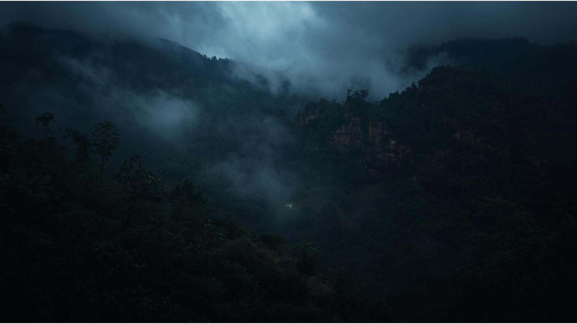 Stone cliffs emerging through cloud
